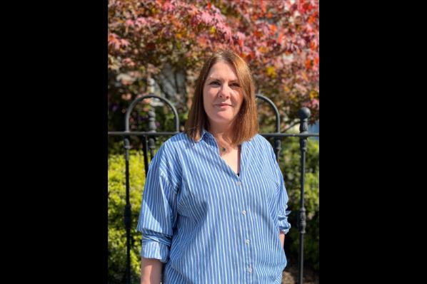 woman in blue shirt in front of tree